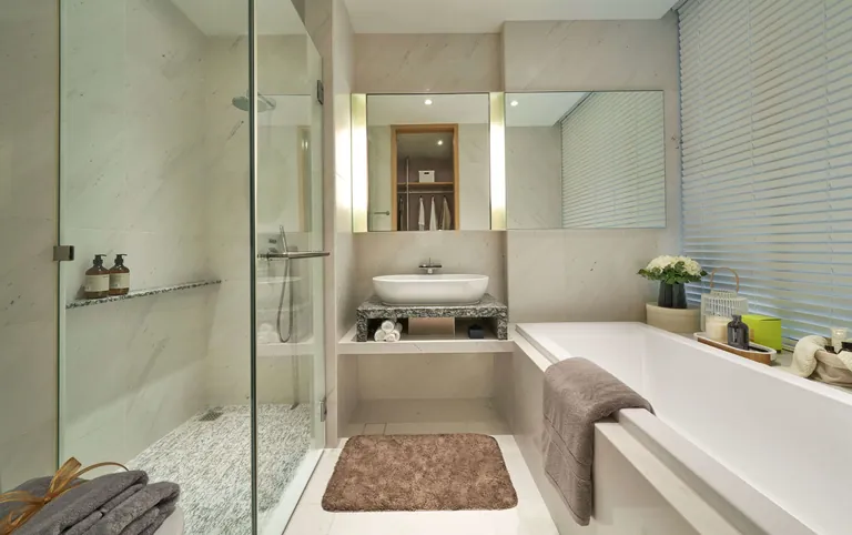 The Residences at W Sentosa Cove, photograph: a master bathroom with a walk-in glass shower, a stone vanity and a built-in bathtub